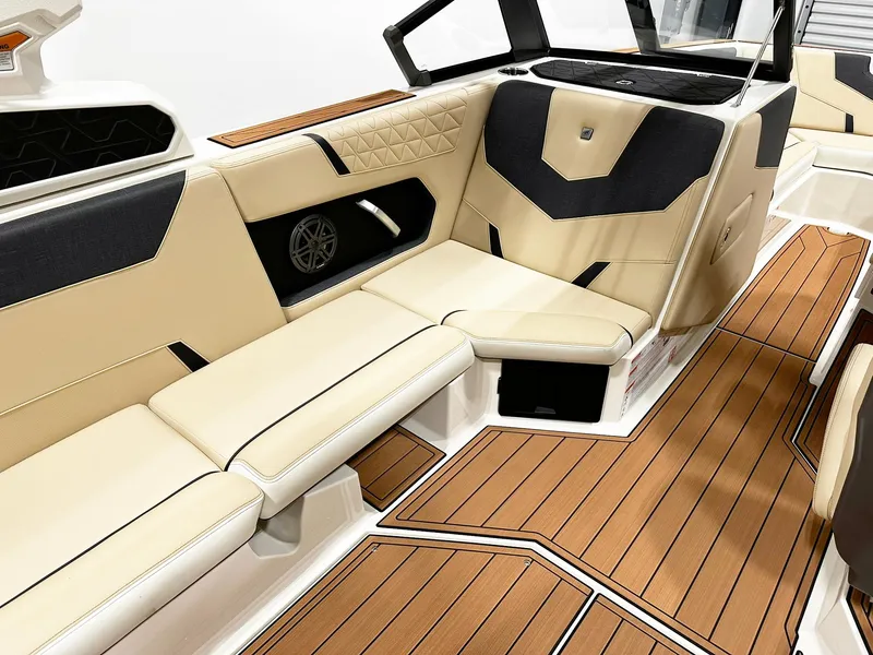 Slide: The Image of 2026 Nautique GS24 boat interior with beige and black seating, teak-style flooring. - 9