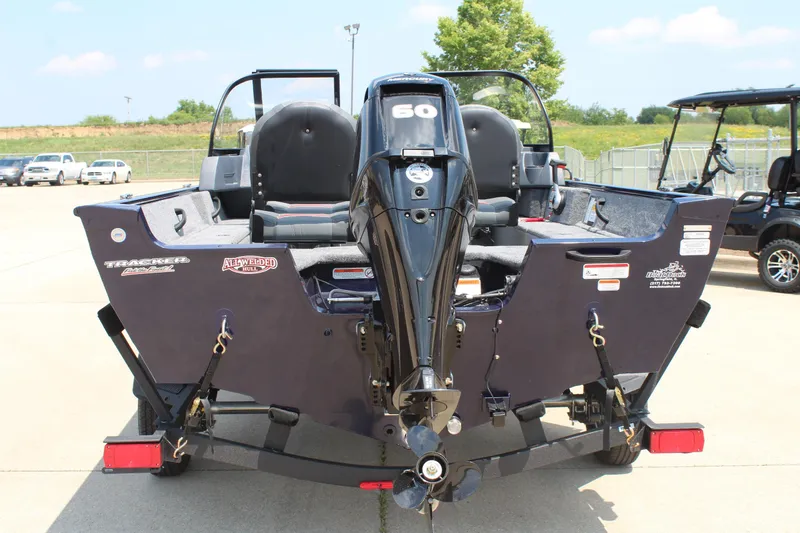 Slide: The Image of 2026 Tracker Pro Guide V-16 WT boat with outboard motor, parked outdoors. - 6
