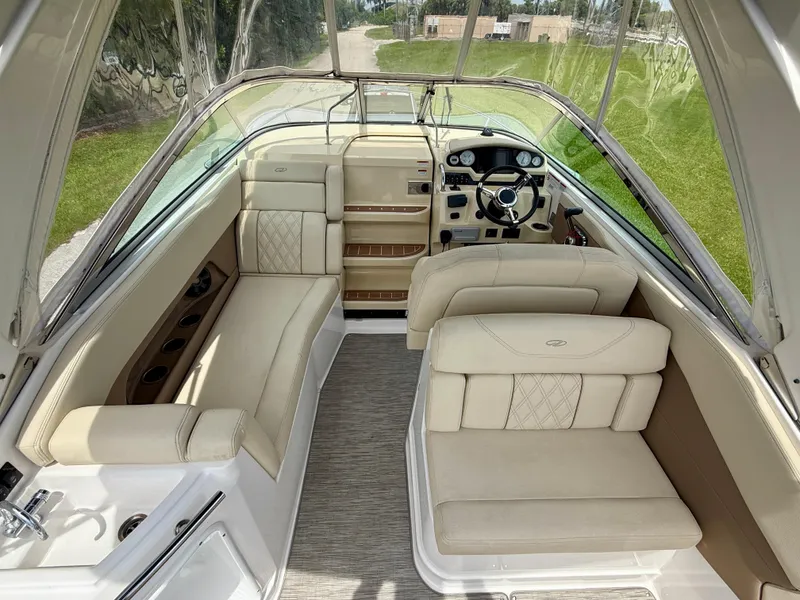 Slide: The Image of 2019 Regal 28 Express boat interior with beige seating and steering console. - 10