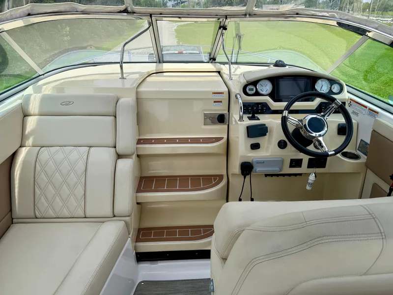 Slide: The Image of 2019 Regal 28 Express boat interior with beige seating and modern dashboard controls. - 11