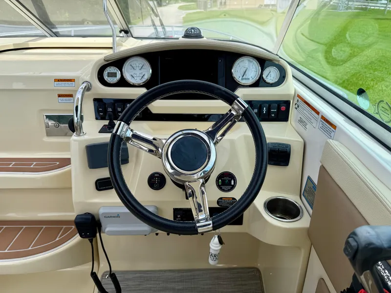 Slide: The Image of 2019 Regal 28 Express boat dashboard with steering wheel and gauges. - 12