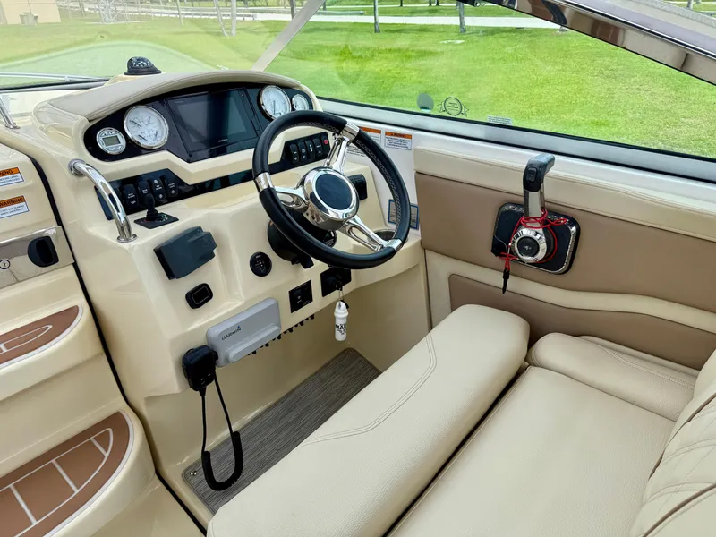 Slide: The Image of 2019 Regal 28 Express boat cockpit with steering wheel and control panel. - 13