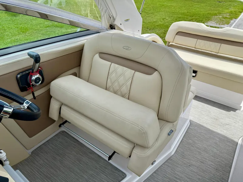 Slide: The Image of 2019 Regal 28 Express boat interior with beige leather seating and steering controls. - 14