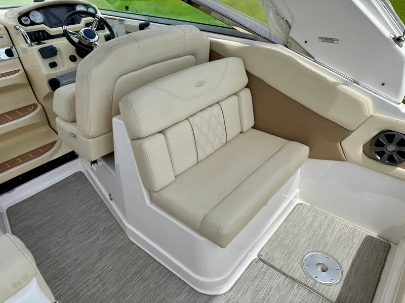 Slide: The Image of 2019 Regal 28 Express boat interior with beige seating and modern dashboard. - 19