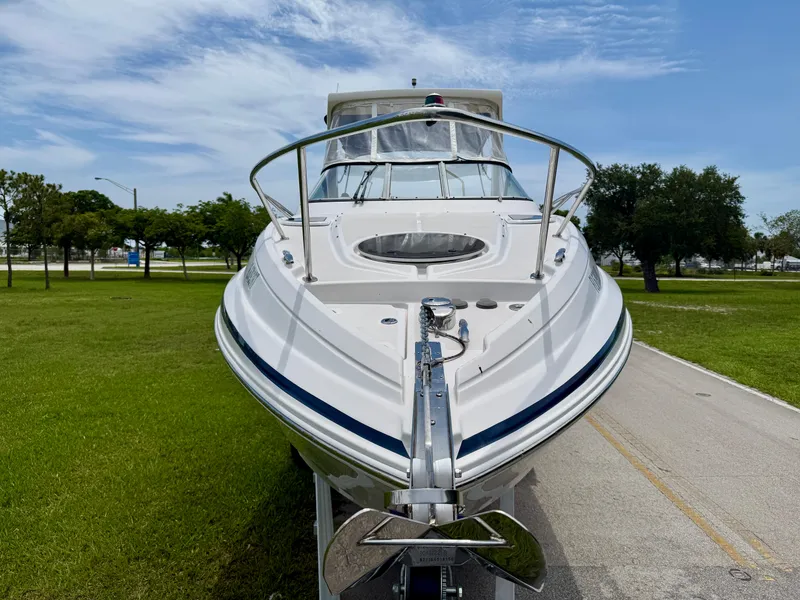 Slide: The Image of 2019 Regal 28 Express boat on trailer, parked on a grassy area under a blue sky. - 2