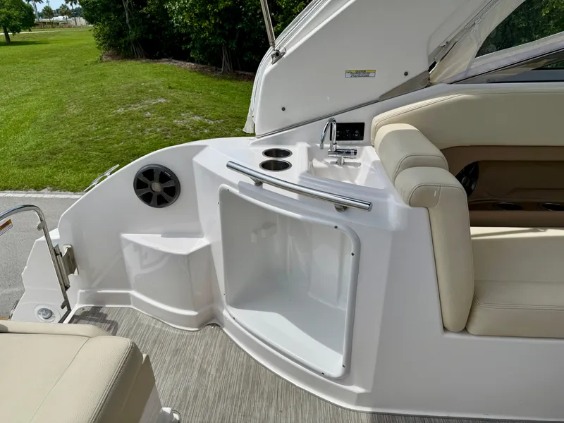 Slide: The Image of 2019 Regal 28 Express boat interior with sink, cup holders, and seating area. - 22