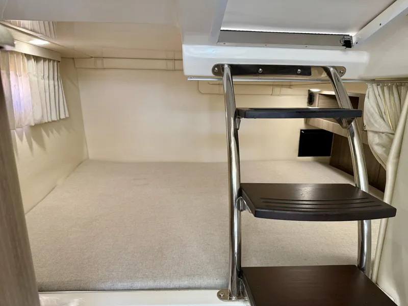 Slide: The Image of 2019 Regal 28 Express cabin interior with ladder and sleeping area. - 31