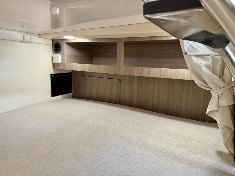 Slide: The Image of 2019 Regal 28 Express cabin interior with wooden shelves and beige upholstery. - 32