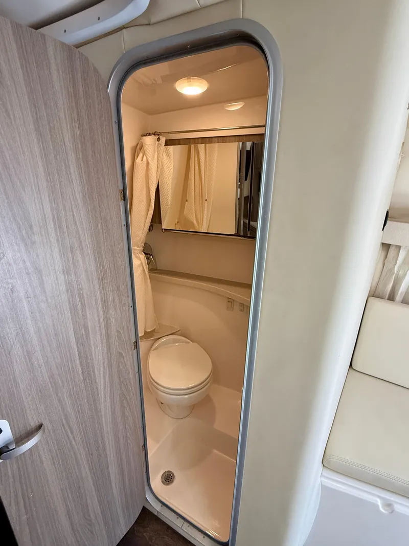Slide: The Image of 2019 Regal 28 Express boat bathroom with toilet, shower, and mirror. - 33