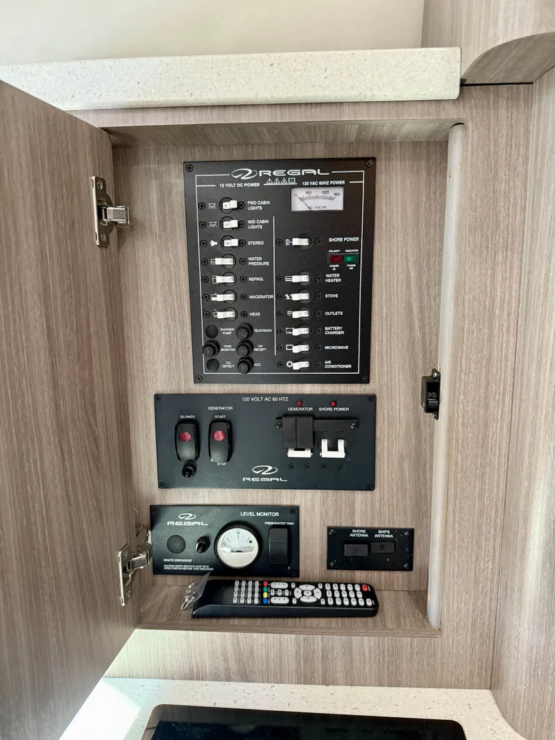 Slide: The Image of Control panel of a 2019 Regal 28 Express boat, featuring switches and a remote. - 35