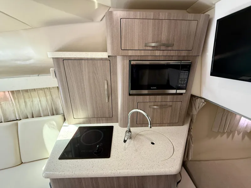 Slide: The Image of Compact kitchen in 2019 Regal 28 Express boat with stove, sink, and microwave. - 36