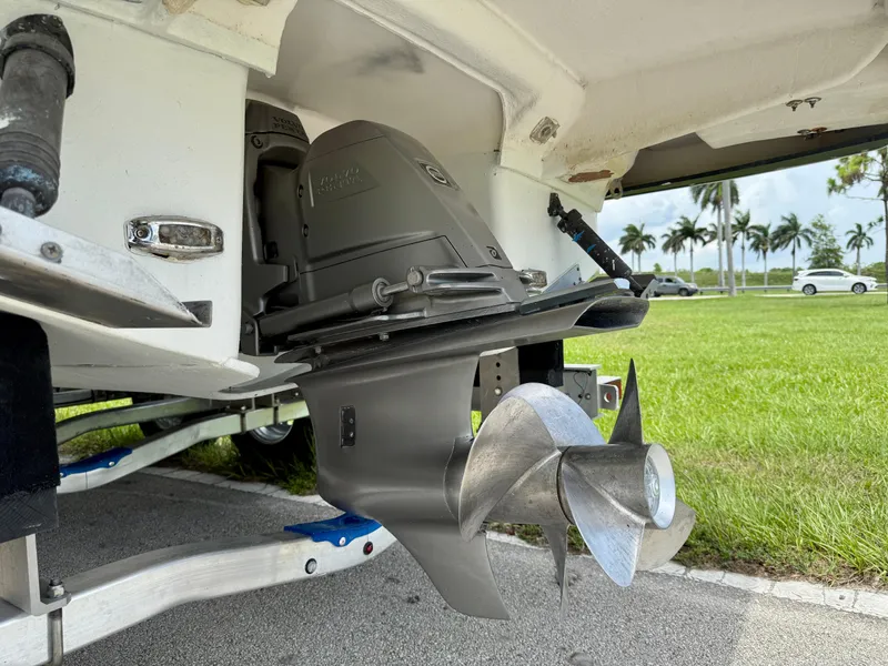 Slide: The Image of 2019 Regal 28 Express boat propeller and engine detail on trailer, with grassy background. - 43