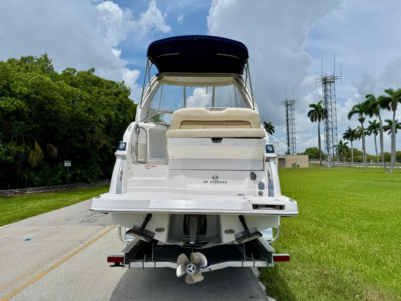 Slide: The Image of 2019 Regal 28 Express boat on road, surrounded by greenery and palm trees. - 6