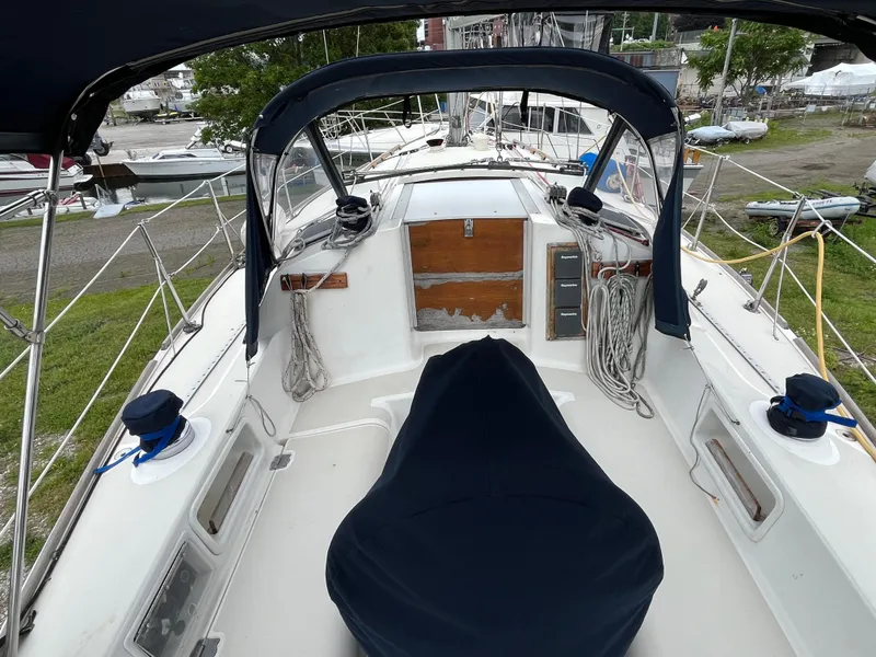 Slide: The Image of 1986 Pearson 33-2 sailboat cockpit with covered seating and rigging, docked in a marina. - 12