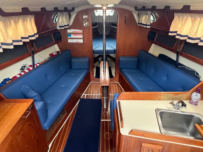 Slide: The Image of Interior of a 1986 Pearson 33-2 sailboat with blue seating and wooden finishes. - 14