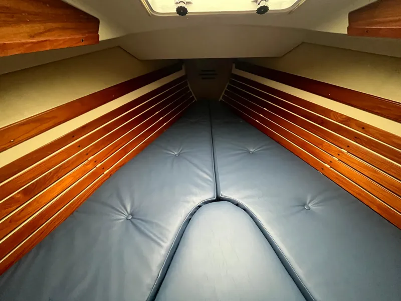 Slide: The Image of Interior cabin of 1986 Pearson 33-2 sailboat with blue cushions and wooden paneling. - 19