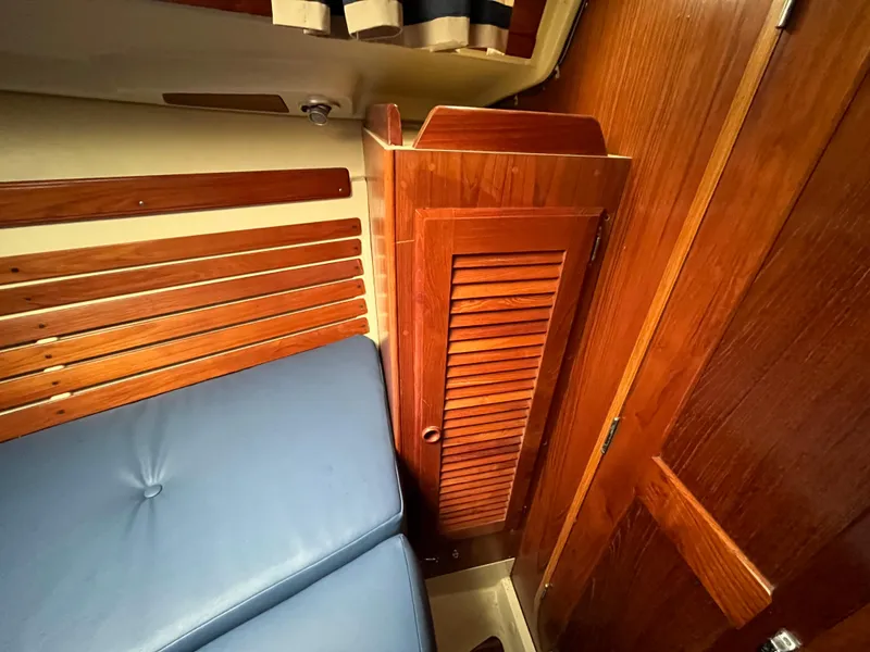 Slide: The Image of Interior of a 1986 Pearson 33-2 sailboat with wooden cabinetry and blue seating. - 20