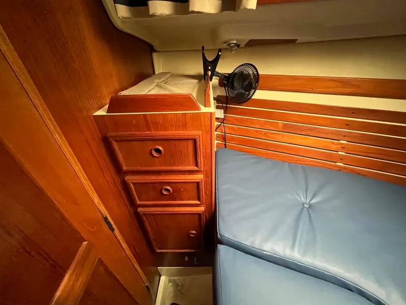 Slide: The Image of Interior of 1986 Pearson 33-2 sailboat with wooden drawers and blue cushioned seating. - 21
