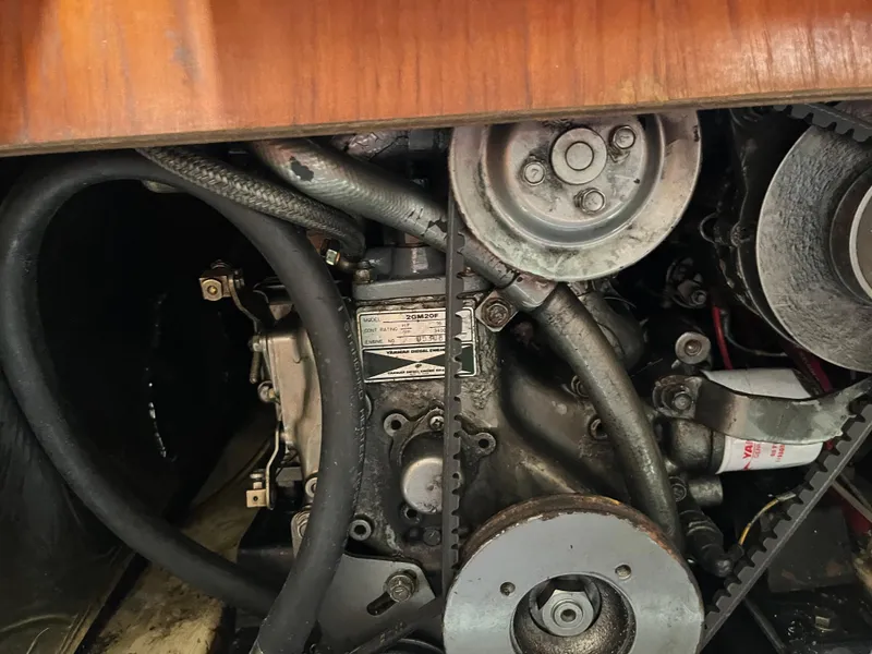 Slide: The Image of Engine compartment of a 1986 Pearson 33-2 sailboat, featuring mechanical components and belts. - 25