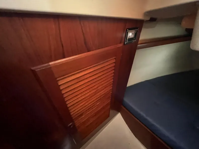 Slide: The Image of Interior of a 1986 Pearson 33-2 sailboat with wooden paneling and a cushioned berth. - 29