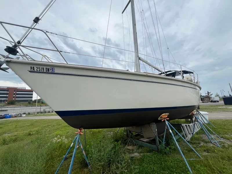 Slide: The Image of 1986 Pearson 33-2 sailboat on stands, displayed outdoors under cloudy skies. - 6
