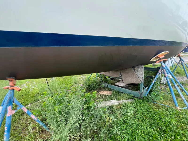 Slide: The Image of Pearson 33-2 sailboat hull on stands, surrounded by grass, 1986 model. - 7
