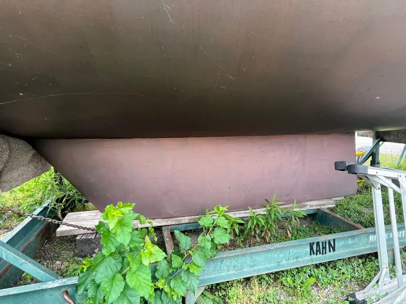 Slide: The Image of 1986 Pearson 33-2 sailboat hull on trailer with greenery. - 8