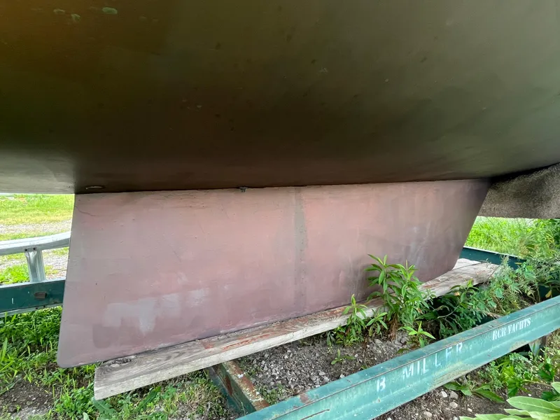 Slide: The Image of 1986 Pearson 33-2 sailboat keel on trailer with greenery. - 9