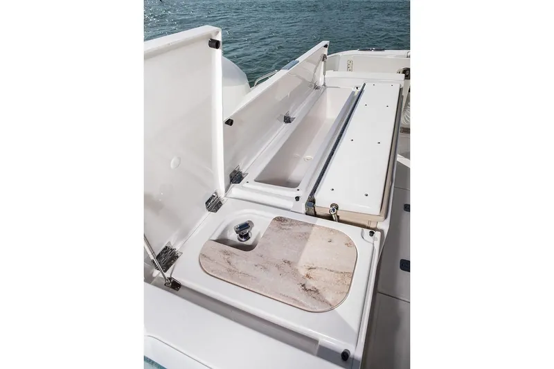Slide: The Image of Manufacturer Provided Image: 2020 Pursuit S 368 Sport boat storage compartments and cutting board. - 12
