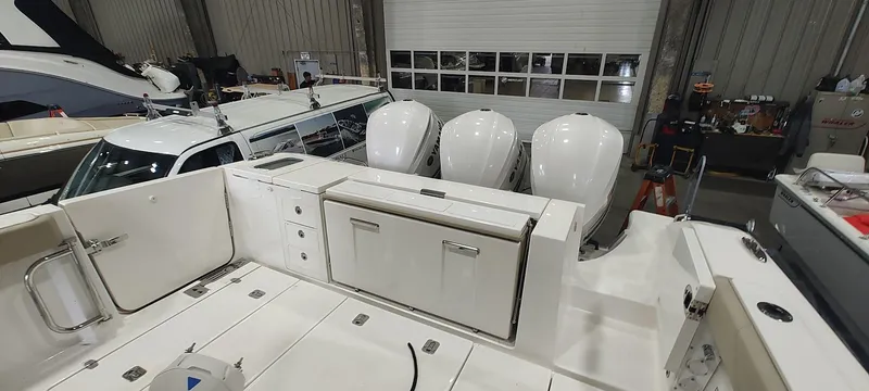 Slide: The Image of 2020 Pursuit S 368 Sport boat with triple outboard engines in a storage facility. - 19