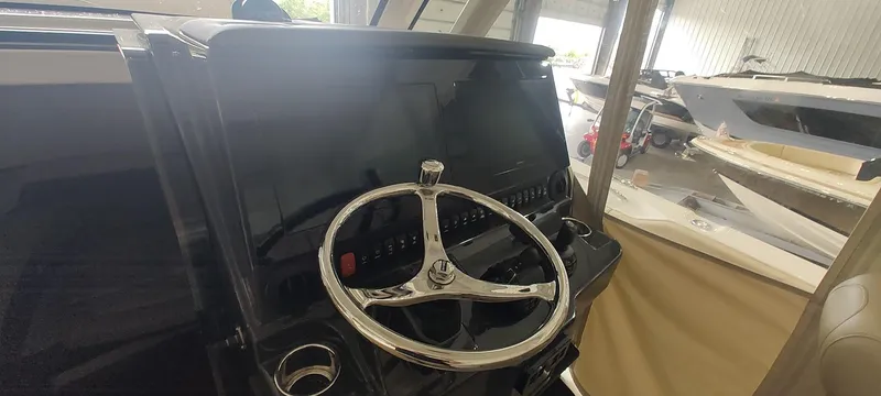 Slide: The Image of 2020 Pursuit S 368 Sport boat helm with steering wheel and control panel. - 23