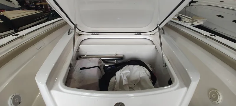 Slide: The Image of Open storage compartment on a 2020 Pursuit S 368 Sport boat, containing various items. - 25