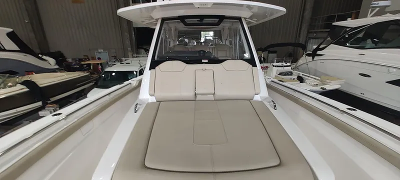 Slide: The Image of 2020 Pursuit S 368 Sport boat with spacious deck and seating in a showroom. - 27