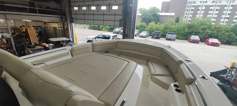 Slide: The Image of 2020 Pursuit S 368 Sport boat interior with beige seating in a garage setting. - 28