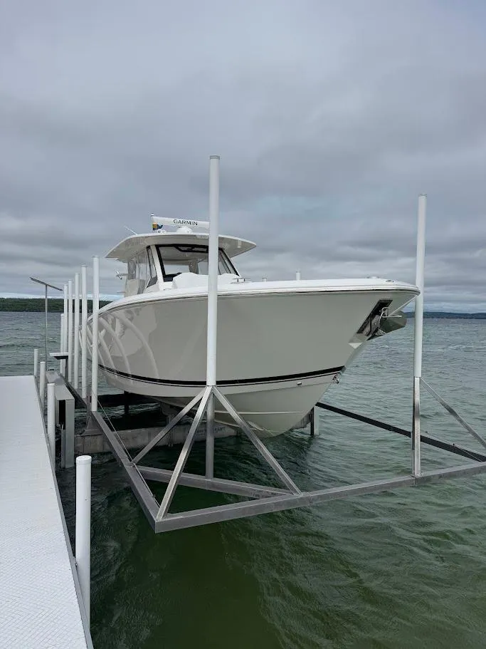 Slide: The Image of 2020 Pursuit S 368 Sport boat on lift at dock, overcast sky. - 3