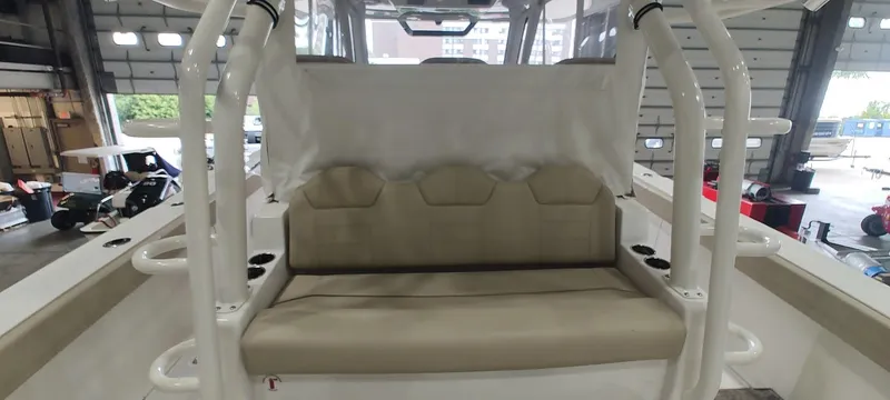 Slide: The Image of 2020 Pursuit S 368 Sport boat interior with beige seating in a garage setting. - 30