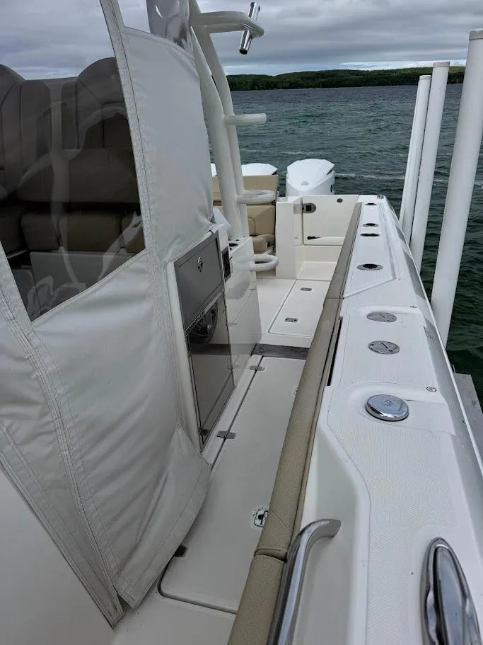 Slide: The Image of 2020 Pursuit S 368 Sport boat deck with seating and storage, on a lake. - 34