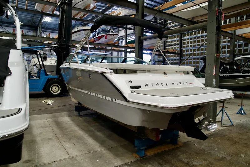 Slide: The Image of 2026 Four Winns H2 boat in a storage facility, rear view. - 5