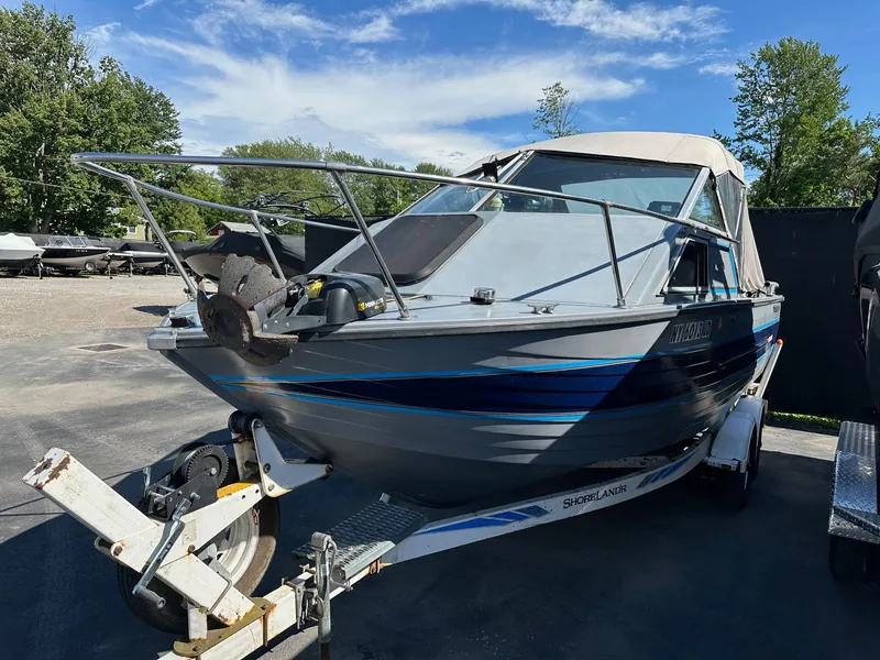 Slide: The Image of 1990 Crestliner 21 Sabre boat on trailer, parked outdoors under blue sky. - 3