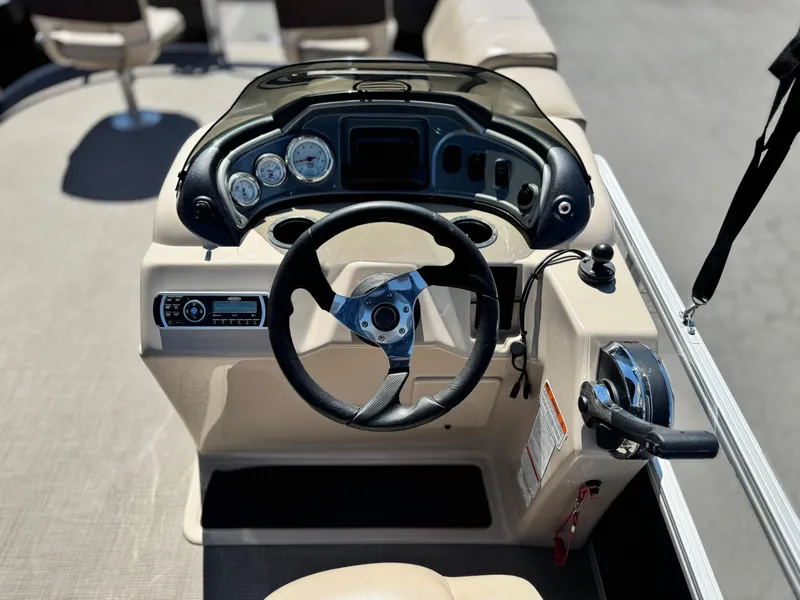 Slide: The Image of 2019 Sun Tracker Fishin' Barge 20 DLX steering console with gauges and controls. - 19