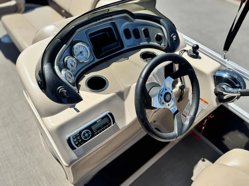 Slide: The Image of 2019 Sun Tracker Fishin' Barge 20 DLX dashboard with steering wheel and controls. - 20