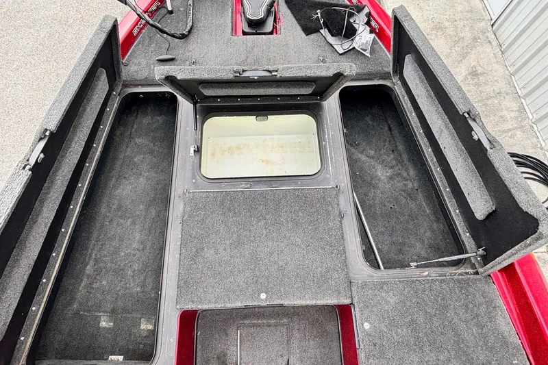 Slide: The Image of 2007 Skeeter ZX 200 boat interior with open storage compartments and carpeted flooring. - 4