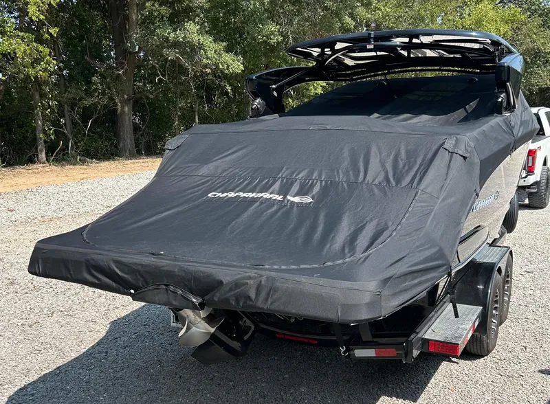 Slide: The Image of 2022 Chaparral 307 SSX boat covered on trailer, parked outdoors. - 12