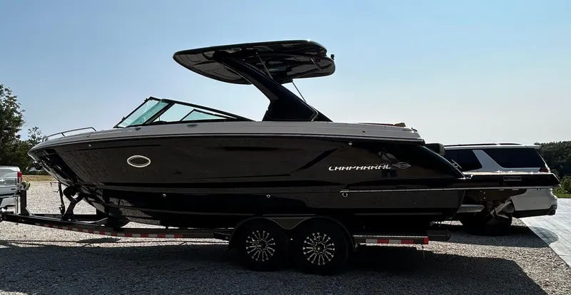 Slide: The Image of 2022 Chaparral 307 SSX boat on trailer, sleek black design, parked outdoors. - 2