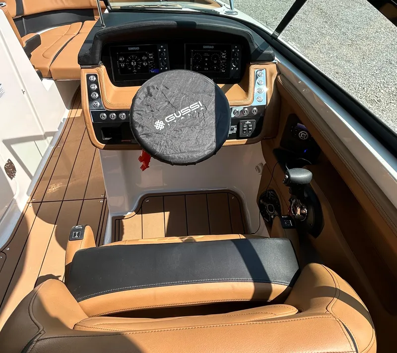 Slide: The Image of 2022 Chaparral 307 SSX boat cockpit with tan leather seating and modern controls. - 8