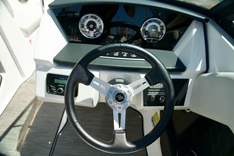 Slide: The Image of Steering wheel and dashboard of 2026 Four Winns H4 boat, featuring modern controls and gauges. - 12