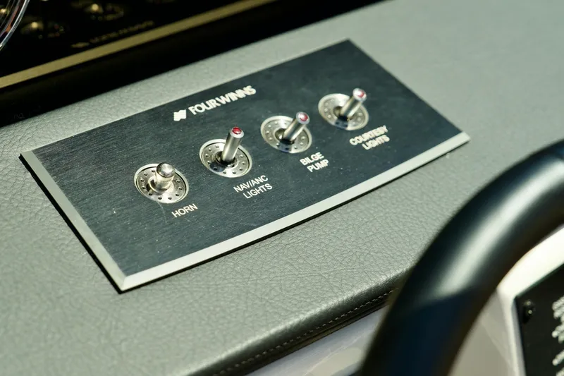 Slide: The Image of Control panel of 2026 Four Winns H4 boat with switches for horn, lights, and pump. - 14