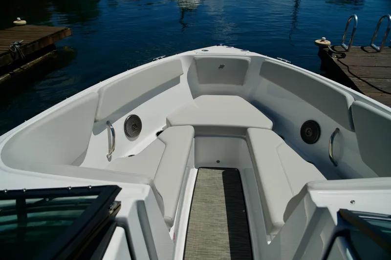 Slide: The Image of 2026 Four Winns H4 boat interior with white seating and speakers, docked by the water. - 17