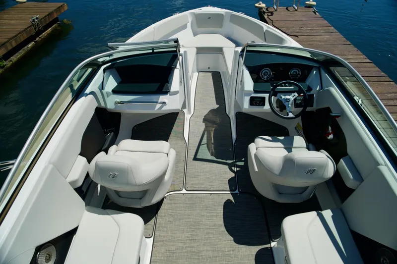 Slide: The Image of 2026 Four Winns H4 boat interior with sleek seating and modern dashboard, docked by the water. - 6