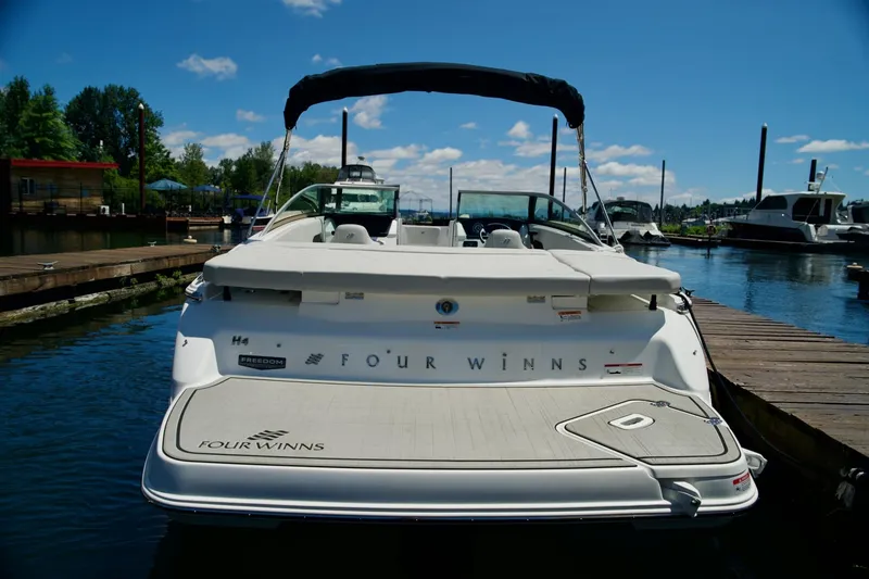 Slide: The Image of 2026 Four Winns H4 boat docked at marina under clear blue sky. - 8
